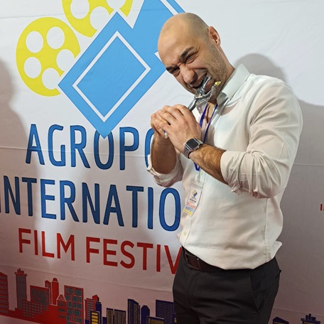 "Director Samuel Lodato biting Best Trailer award for 'Remi Milligan: Lost Director' at Agropoli International Film Festival.