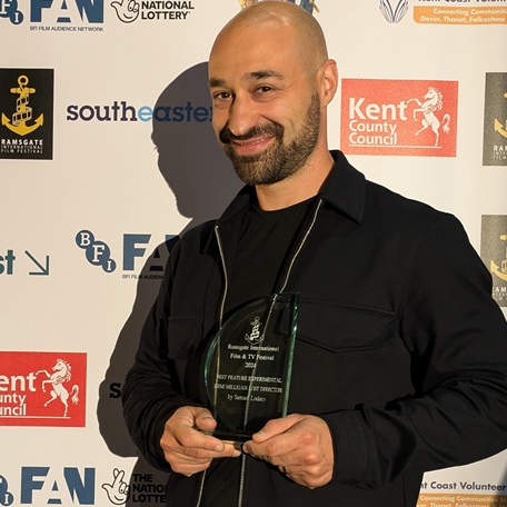 Director Samuel Lodato holding Best Experimental Feature award for 'Remi Milligan: Lost Director' at Ramsgate International Film & TV Festival.